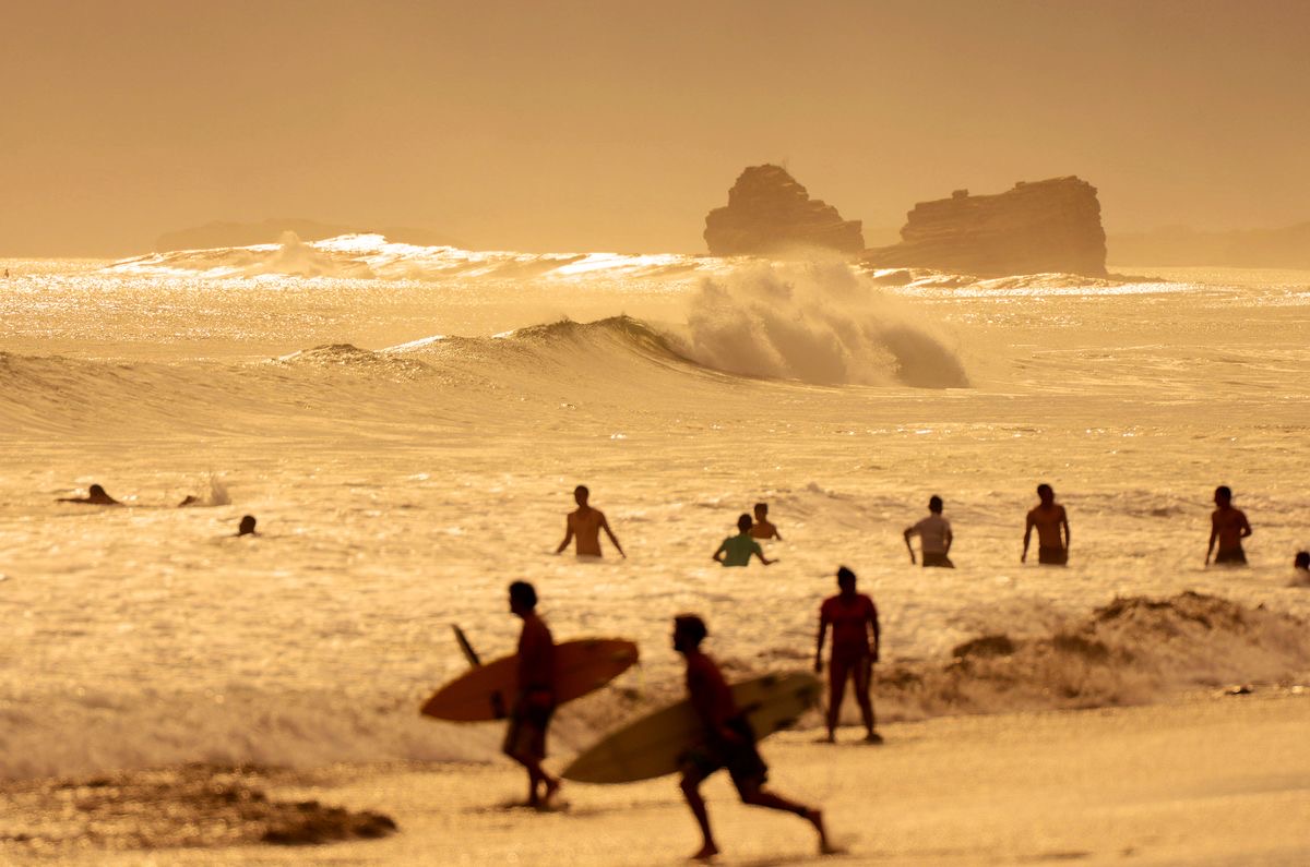 Surfers in golden light at sunset · the California coastline of BELDI